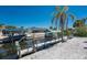Waterfront backyard with dock featuring boat lift and canopy, surrounded by white shell landscaping at 2673 Titania Rd, Englewood, FL 34224