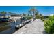 Canal side dock with boat lift surrounded by crushed shells at 2673 Titania Rd, Englewood, FL 34224