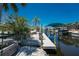 Wooden dock with boat lift, surrounded by white shell landscaping, leading to the canal and waterfront property at 2673 Titania Rd, Englewood, FL 34224