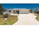 Charming single-story home with a well-manicured lawn and a spacious driveway leading to an attached garage at 2673 Titania Rd, Englewood, FL 34224