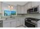A spacious kitchen features marble countertops, a tile backsplash, and stainless steel appliances at 2673 Titania Rd, Englewood, FL 34224