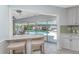 Eat-in kitchen with marble countertops and views of the outdoor pool area at 2673 Titania Rd, Englewood, FL 34224