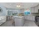 Bright kitchen featuring stainless steel appliances, a center island, and a breakfast bar overlooking the pool area at 2673 Titania Rd, Englewood, FL 34224