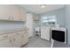 Bright laundry room with tile floor, window, sink and modern washer and dryer at 2673 Titania Rd, Englewood, FL 34224