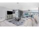 Spacious living area with a white sectional, TV, built-in shelving, and a view of the pool at 2673 Titania Rd, Englewood, FL 34224