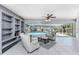 Bright sunroom overlooking pool with built-in shelves, neutral furniture, and tile floors at 2673 Titania Rd, Englewood, FL 34224