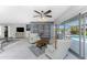 Open concept living area featuring built in shelves, tile floors, fan, and view to pool at 2673 Titania Rd, Englewood, FL 34224