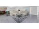 Bright living room featuring a comfortable beige sectional, stylish rug, and tile flooring at 2673 Titania Rd, Englewood, FL 34224