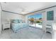 Bright main bedroom featuring a king-size bed, sliding glass doors, and an eye-catching ensuite pool view at 2673 Titania Rd, Englewood, FL 34224