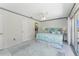 Bright main bedroom with tile flooring, neutral walls, and a cozy bed with blue accents at 2673 Titania Rd, Englewood, FL 34224