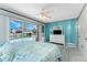 Bright main bedroom boasts sliding glass doors to the pool, ceiling fan, and a dresser with curtains at 2673 Titania Rd, Englewood, FL 34224