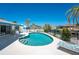 Beautiful kidney-shaped pool with sunny patio, tropical landscaping, and fenced yard at 2673 Titania Rd, Englewood, FL 34224