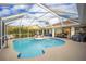 Beautiful screened-in pool with lounge chairs, dining, and grilling areas perfect for entertaining at 2845 Cabaret St, Port Charlotte, FL 33948