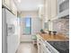 Bright kitchen with a view of the ocean, white cabinets, granite counters, and modern appliances at 2950 N Beach Rd # B324, Englewood, FL 34223