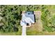 Aerial view of house with a metal roof, long driveway, and screened pool, surrounded by tropical vegetation at 2957 Montgomery Dr, Port Charlotte, FL 33981