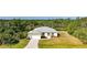 Exterior aerial view of a one-story home with a light-colored exterior, metal roof, and attached two-car garage at 2957 Montgomery Dr, Port Charlotte, FL 33981
