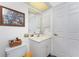 Bathroom with white vanity, toilet, tile flooring, and framed photos on the wall at 311 Boundary Blvd, Rotonda West, FL 33947