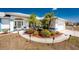 Charming home with a well-manicured front yard featuring lush landscaping and mature trees at 311 Boundary Blvd, Rotonda West, FL 33947