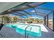 Sparkling screened-in pool with inviting lounge area under the shade and clear blue skies at 311 Boundary Blvd, Rotonda West, FL 33947