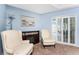 Sitting room with two armchairs, an electric fireplace, and access to a patio at 311 Boundary Blvd, Rotonda West, FL 33947