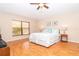 Bedroom boasting with a large window, wood floors, ceiling fan, and a queen size bed at 3593 Birmingham Ln, North Port, FL 34288