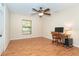 Bright bedroom features a ceiling fan, wood floors, and a computer desk setup at 3593 Birmingham Ln, North Port, FL 34288