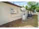 Exterior of the home with Generac generator, AC unit, and satellite dish surrounded by green grass and trees at 3593 Birmingham Ln, North Port, FL 34288