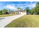 Charming single-story home with a well-manicured lawn and a long driveway leading to a two-car garage at 3593 Birmingham Ln, North Port, FL 34288