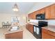 Modern kitchen with wood cabinetry, stainless steel appliances, granite countertops, and a breakfast nook at 3593 Birmingham Ln, North Port, FL 34288