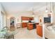 Well-lit kitchen showcasing wooden cabinetry, granite countertops, stainless appliances, and an adjacent dining area at 3593 Birmingham Ln, North Port, FL 34288