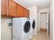 Convenient laundry room with front-load washer and dryer and ample cabinet space at 3593 Birmingham Ln, North Port, FL 34288