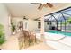 Covered patio with comfortable seating next to an enclosed pool area and tropical landscaping at 3593 Birmingham Ln, North Port, FL 34288
