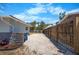 Fenced-in backyard with a gravel area, partial landscaping and a neutral-toned home at 360 E Wentworth Cir, Englewood, FL 34223