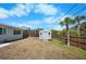 Backyard showing storage shed, partial fence, and mature palm trees at 360 E Wentworth Cir, Englewood, FL 34223