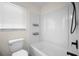 Clean bathroom featuring a white bathtub, toilet, and shelving at 360 E Wentworth Cir, Englewood, FL 34223