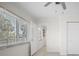 Bright bedroom featuring a ceiling fan, white walls, large window, and closet for ample storage at 360 E Wentworth Cir, Englewood, FL 34223