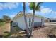 Back of home featuring lush landscaping, decorative stone accents, and an air conditioning unit at 360 E Wentworth Cir, Englewood, FL 34223