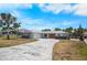 Charming single-story home with a well-manicured front yard, a long driveway, and a two-car garage at 360 E Wentworth Cir, Englewood, FL 34223
