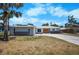 Charming single-story home with a well-manicured front yard, a long driveway, and a two-car garage at 360 E Wentworth Cir, Englewood, FL 34223