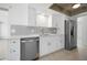 Bright kitchen featuring stainless steel appliances, white cabinets, tile backsplash and quartz countertops at 360 E Wentworth Cir, Englewood, FL 34223
