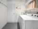 Functional laundry room with a modern washer and dryer setup and overhead shelving at 360 E Wentworth Cir, Englewood, FL 34223