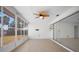 Enclosed sunroom with fan, light tile floors and large windows offers a view of the backyard at 360 E Wentworth Cir, Englewood, FL 34223