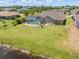 Aerial view of a home featuring a screened pool, large yard, and a lake at 39 Medalist Ln, Rotonda West, FL 33947