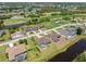 Aerial view of homes in community featuring water features and a golf course at 39 Medalist Ln, Rotonda West, FL 33947