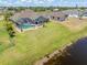 An aerial view of the home with a screened-in pool and lush green backyard, bordering a tranquil lake at 39 Medalist Ln, Rotonda West, FL 33947