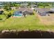 Aerial view of home featuring a screened pool, large yard and lake view at 39 Medalist Ln, Rotonda West, FL 33947