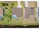 Aerial view of a home with screened pool and adjacent vacant lot on a lake at 39 Medalist Ln, Rotonda West, FL 33947