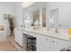 Bright bathroom with double sinks, white cabinetry, and a large mirror at 39 Medalist Ln, Rotonda West, FL 33947