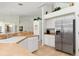 Spacious kitchen with stainless steel refrigerator, white cabinets, and breakfast bar at 39 Medalist Ln, Rotonda West, FL 33947