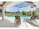 Relaxing screened-in pool area with chairs, table, and great backyard view at 39 Medalist Ln, Rotonda West, FL 33947